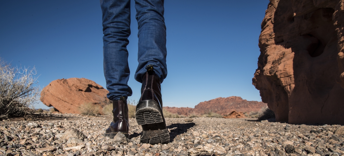Close up of person's shoes walking away from camera into a desert